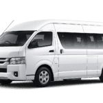 Toyota Hiace Commuter Luxury putih tampak serong depan dan samping untuk layanan sewa Hiace Luxury Tangerang dengan driver profesional